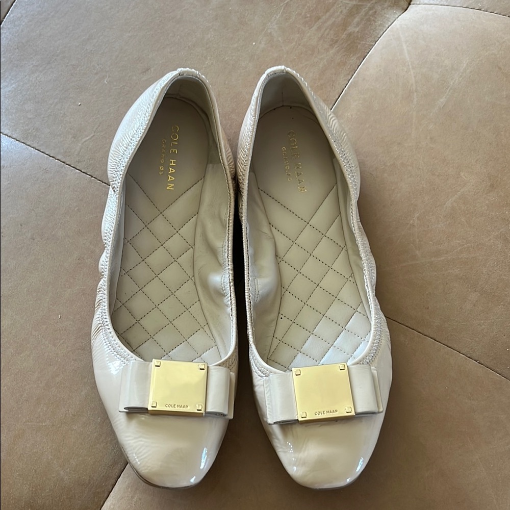 Cole haan grand o.s. cream patent ballet flat with gold bow detail.